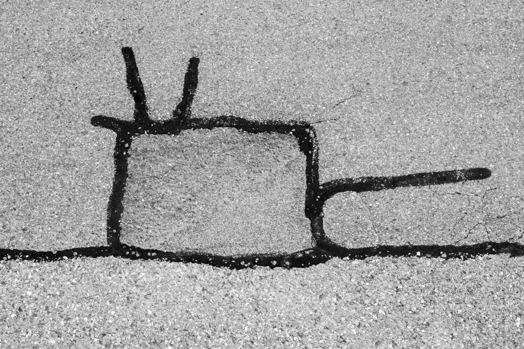 &Eacute;tude &ndash; ligne sombre de r&eacute;paration suivant une fissure et formant un trac&eacute; graphique sur l&rsquo;asphalte, photographie de Joseph Emile